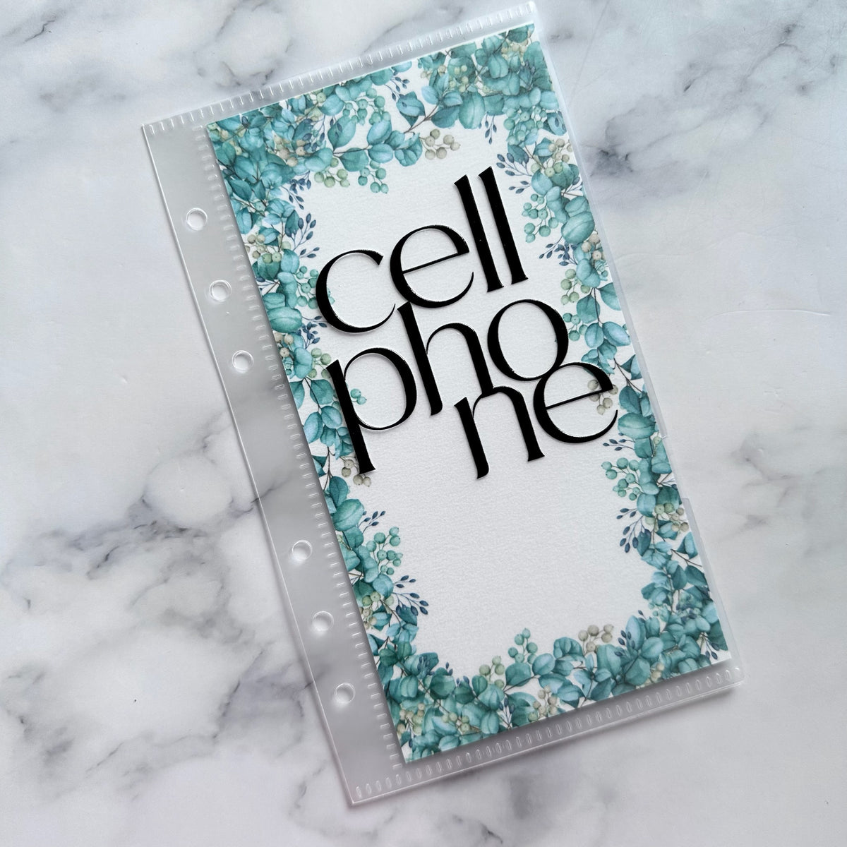 Phone case with floral design and 'cell phone' text on a marble background
