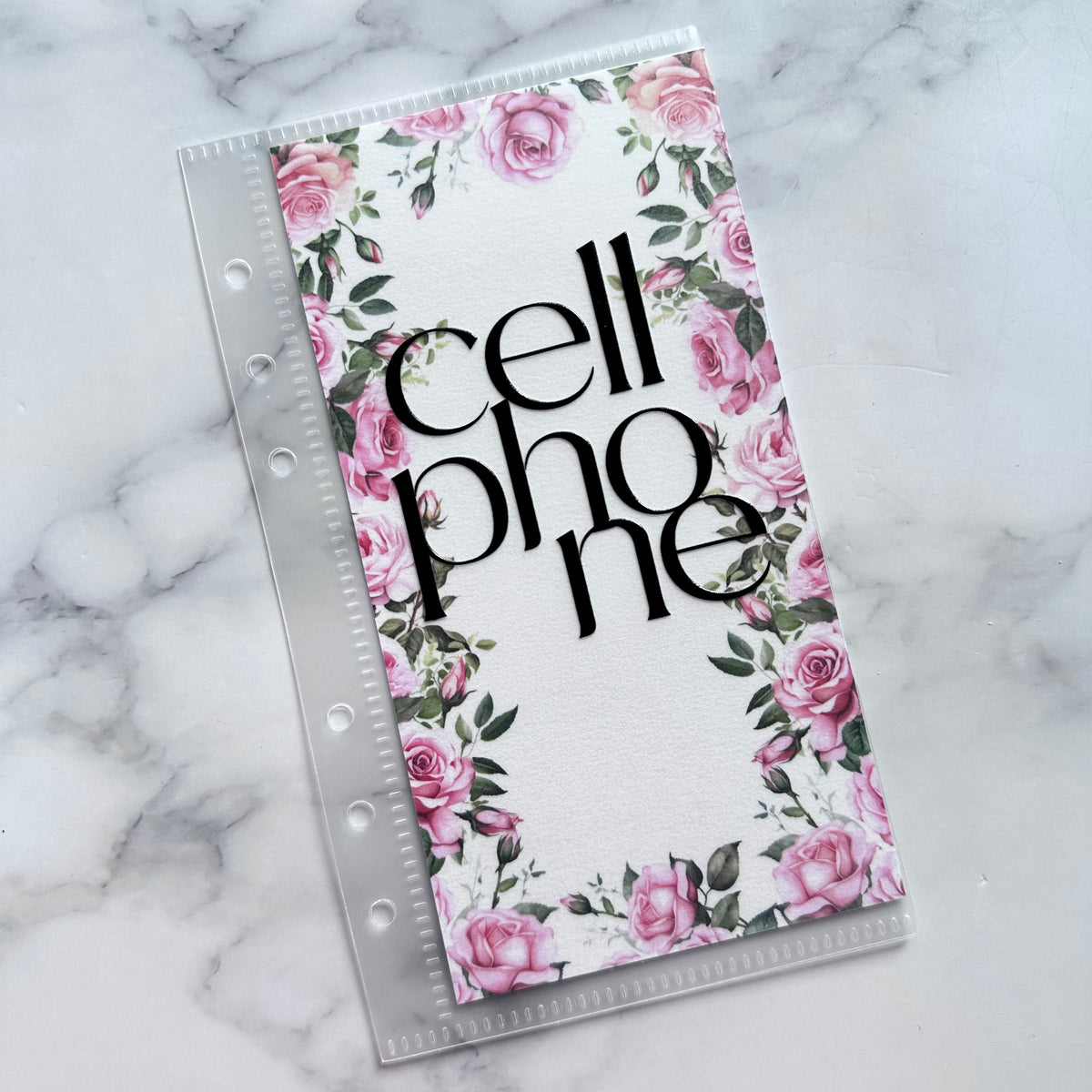 Floral phone case with 'cell phone' text on a marble background